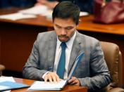 Philippine Senator and boxing champion Manny Pacquiao reads his briefing materials as he prepares for the Senate session in Pasay city, Metro Manila, Philippines September 20, 2016. Picture taken September 20, 2016. REUTERS/Erik De Castro