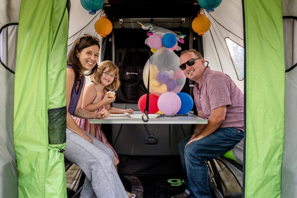 Annie, 9, who suffers from congenital heart disease, poses with her parents, Clay and Emily, after receiving a GO Camping Trailer, thanks to SylvanSport and Make-A-Wish Central & Western North Carolina.