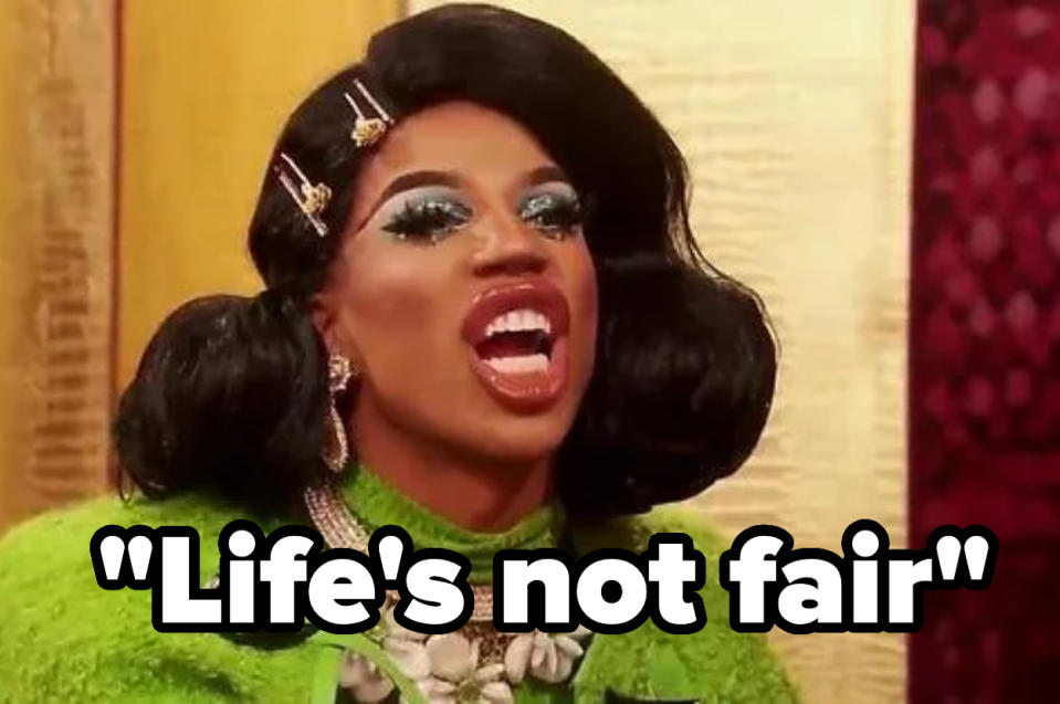 Drag queen in glam makeup and green outfit with bold jewelry, saying "Life's not fair" in large text at the bottom