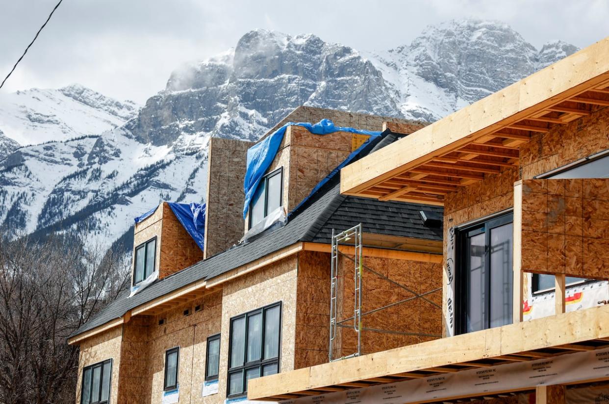 Mountains loom over condos being constructed in Canmore, Alta., on Monday, April 24, 2023. (Jeff McIntosh/The Canadian Press - image credit)