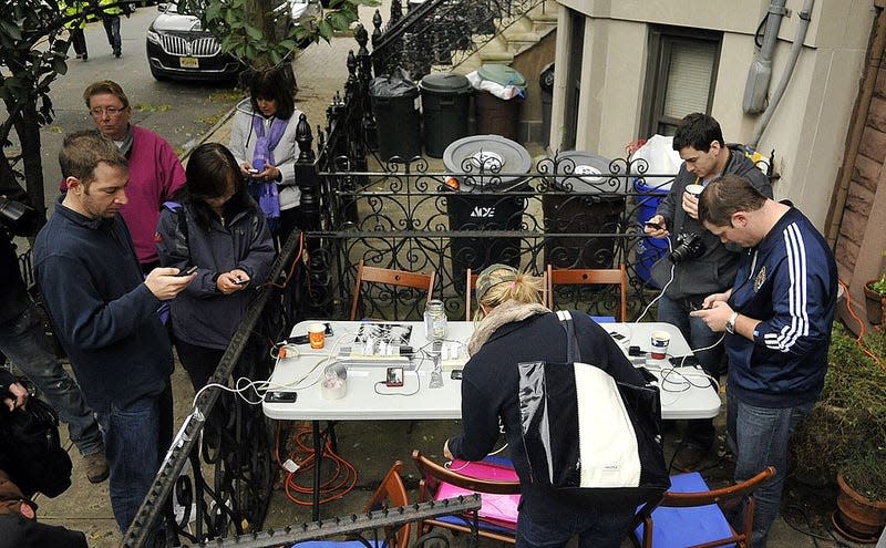 Residents charge their mobile devices at a station set up by Lucy Walkowiak, 11, who collected for donations to aid victims of Hurricane Sandy, October 31, 2012 in Hoboken, New Jersey. 