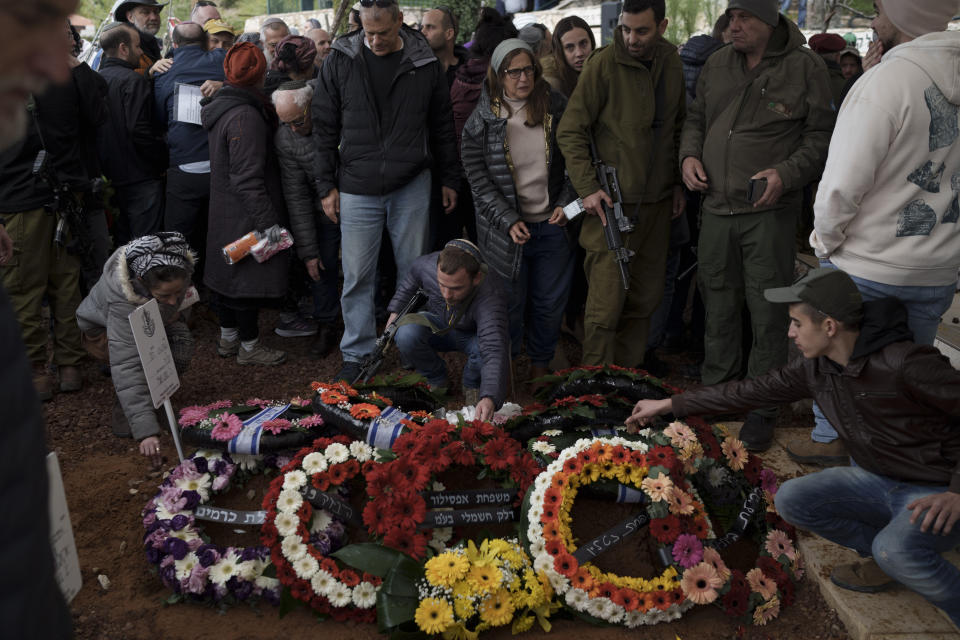 Family and friends of Israeli reservist warrant officer Yuval Nir mourn over his grave during his funeral at a cemetery in the West Bank settlement of Kfar Etzion, Israel, Wednesday, Jan. 31, 2024. Nir, 43, was killed during Israel's ground operation in the Gaza Strip, where the Israeli army has been battling Palestinian militants in the war ignited by Hamas' Oct. 7 attack into Israel. (AP Photo/Leo Correa)