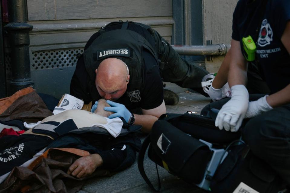 Security guard Michael Bock performs CPR on a man who overdosed, and regained conscious soon after, in downtown Portland, Ore., on Aug. 2. In America's overwhelmed downtowns, private security guards like Michael Bock have become the solution of last resort.<span class="copyright">Erin Schaff—The New York Times/Redux</span>