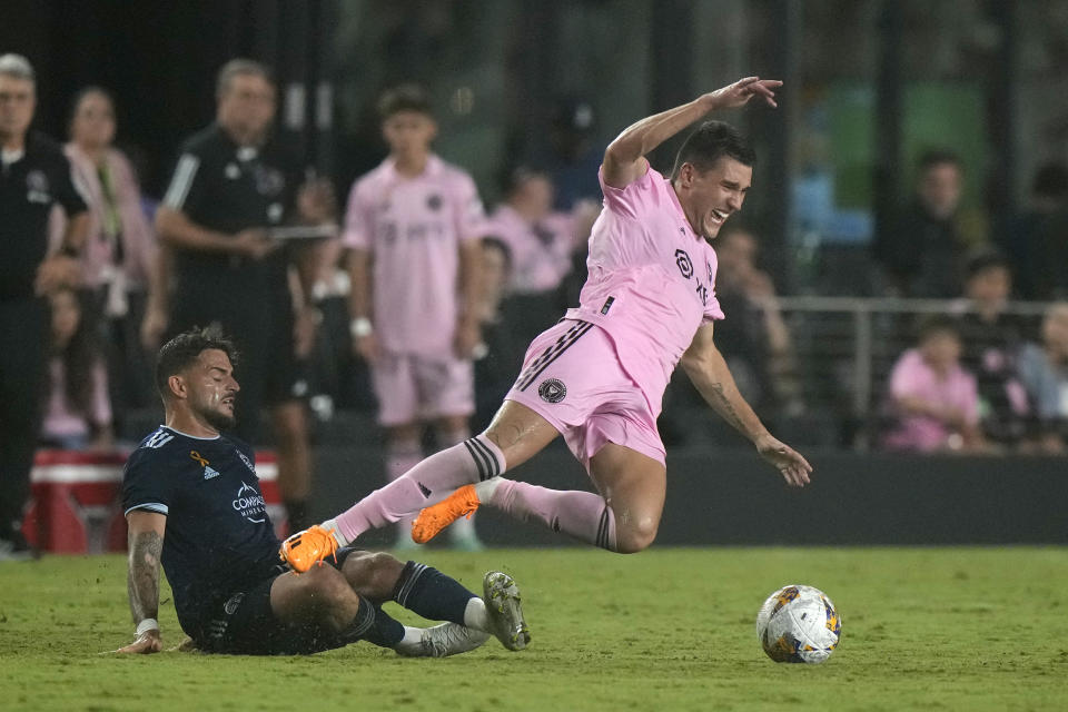 Inter Miami forward Robbie Robinson, right, goes down as he battles for the ball with Sporting Kansas City defender Tim Leibold, Saturday, Sept. 9, 2023, during the second half of an MLS soccer match in Fort Lauderdale, Fla. (AP Photo/Wilfredo Lee)