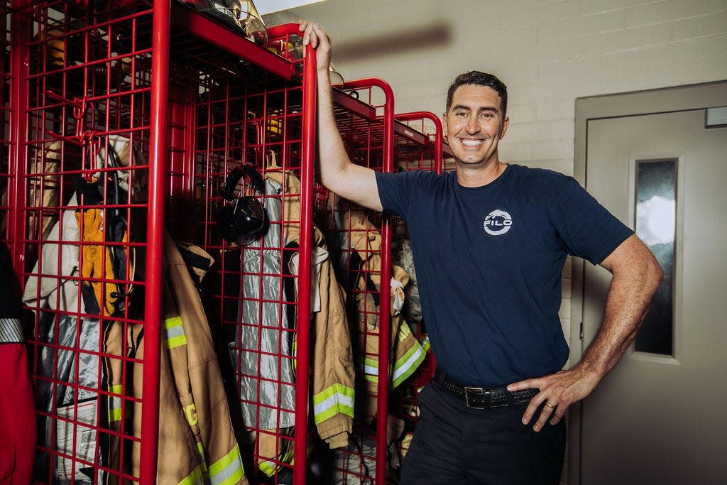 Naval Air Station Jacksonville firefighter Sean Conant models some of the items from his newly launched line of uniforms for firefighters to wear at their stations and under heavy-duty fire scene gear.