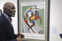 File-In this Jan. 11, 2018 file photo, Alan Page, NFL Hall of Famer and retired Minnesota Supreme Court justice, talks about a poster from the 1972 Olympics in Munich that was done by an African-American artist, which is among the artifacts of slavery and segregation collected by Page and his wife, Diane Sims Page. Page has counted art collection among his many life pursuits, and the former Vikings star has two of his prized pieces up for sale through a New York auction house, each valued at more than $200,000. (AP Photo/Steve Karnowski, File)