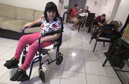 Alma Rivera, 39, waits in front of a television as her mother fixes her a plate of dinner at their home in Kissimmee, Florida, U.S. December 2, 2016. REUTERS/Phelan Ebenhack