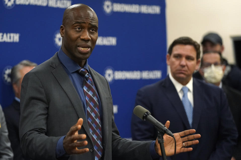 Florida Surgeon Gen. Dr. Joseph A. Ladapo, left, speaks at a news conference with Florida Gov. Ron DeSantis, right, Monday, Jan. 3, 2022, at Broward Health Medical Center in Fort Lauderdale, Fla. (AP Photo/Wilfredo Lee)