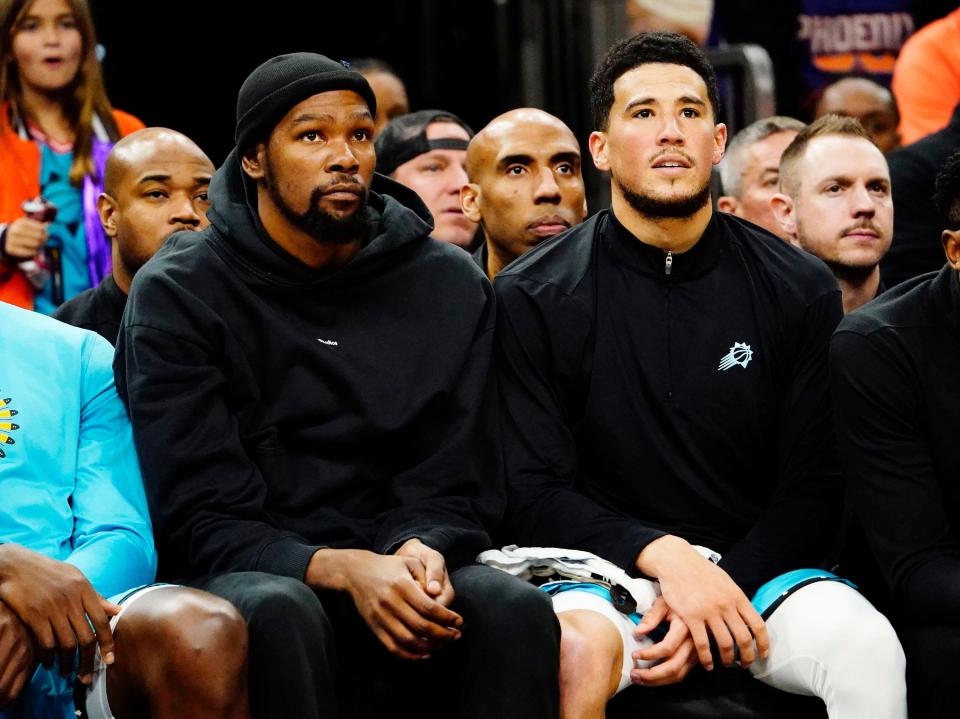 Phoenix Suns forward Kevin Durant (35) and guard Devin Booker (1) watch the action against the Orlando Magic in the second half at Footprint Center in Phoenix on March 16, 2023.