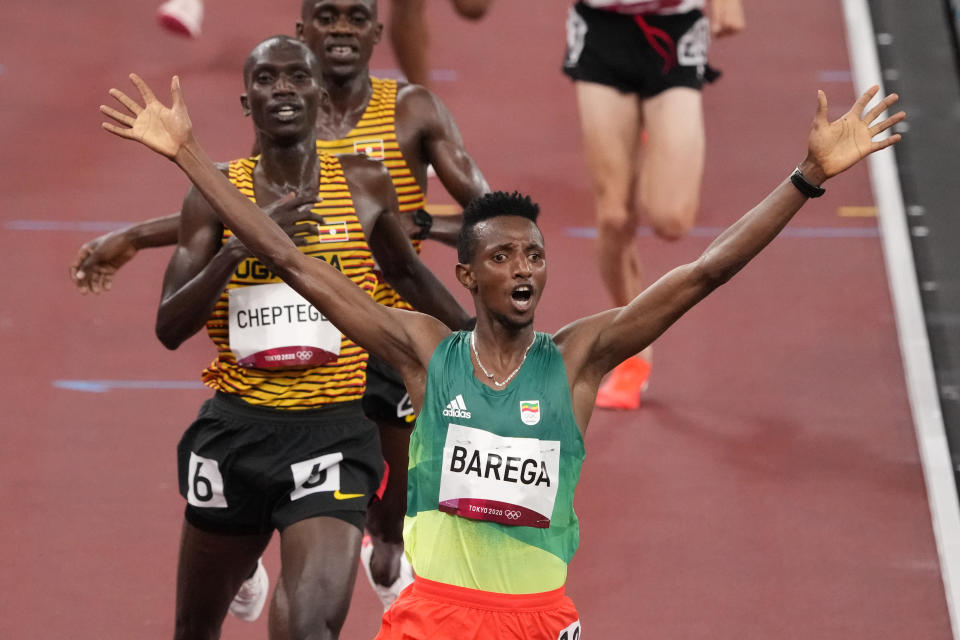 Selemon Barega, of Ethiopia, celebrates after winning the men's 10,000-meter run at the 2020 Summer Olympics, Friday, July 30, 2021, in Tokyo. (AP Photo/Charlie Riedel)