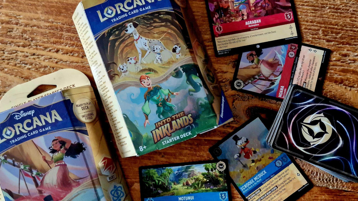  Disney Lorcana Into the Inklands boxes and cards on a wooden table. 