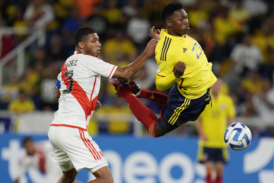 Peru's Jose Sanchez, left, and Colombia's Jorge Cabezas, battle for the ball during a South America U-20 soccer match in Cali, Colombia, Saturday, Jan. 21, 2023. (AP Photo/Fernando Vergara)