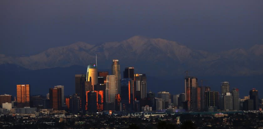 LOS ANGELES, CA - DECEMBER 27, 2019 - Snow covered San Gabriel Mountains provide a wintery backdrop for the downtown Los Angeles skyline on December 27, 2019. Snow is the remnants of two storms that recently passed through the Southland. Another storm is expected to bring more rain to the region on Sunday. (Genaro Molina / Los Angeles Times)
