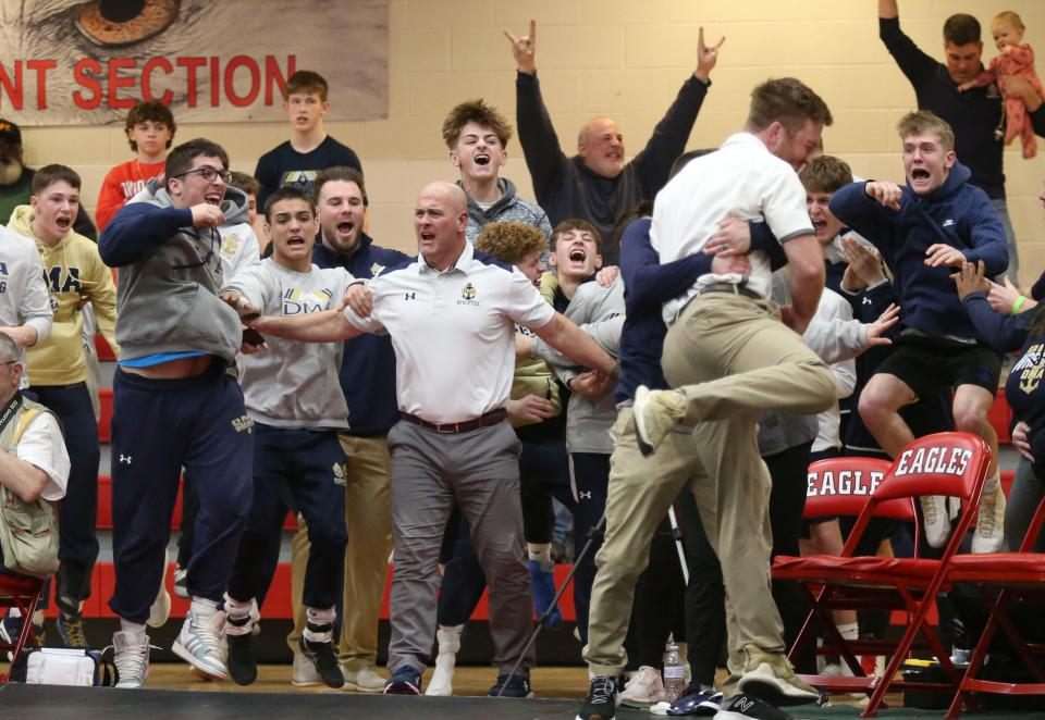 The Delaware Military Academy side explodes in cheers as Hayden Moaney cinches the DIAA Division II Dual Meet team title with a pin at 190 pounds, Saturday Feb. 18, 2023 at Smyrna High School.