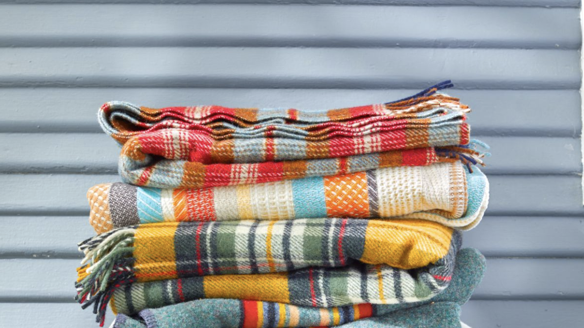 stack of wool blankets resting on a canvas camp stool