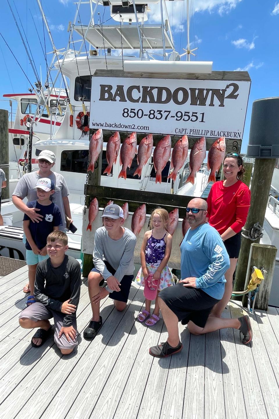 A family poses with their catch of red snapper after a trip aboard the charter boat Backdown2 on Wednesday, the first day of the red snapper fishing season.