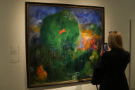 A woman takes photo of the painting by Ukrainian artist Viktor Palmov called 'The 1st of May' during the inauguration of the Ukraine art exposition at the Thyssen-Bornemisza museum in Madrid, Spain, Monday, Nov. 28, 2022. Against a backdrop of Russian attacks, border closures and a nail-biting journey across Europe, Madrid's Thyssen-Bornemisza National Museum has teamed up with Kyiv's National Art Museum of Ukraine to secretly bring dozens of Ukrainian 20th century avant garde artworks by road to the Spanish capital for a unique exhibition and statement of support for the war-torn country. (AP Photo/Paul White)