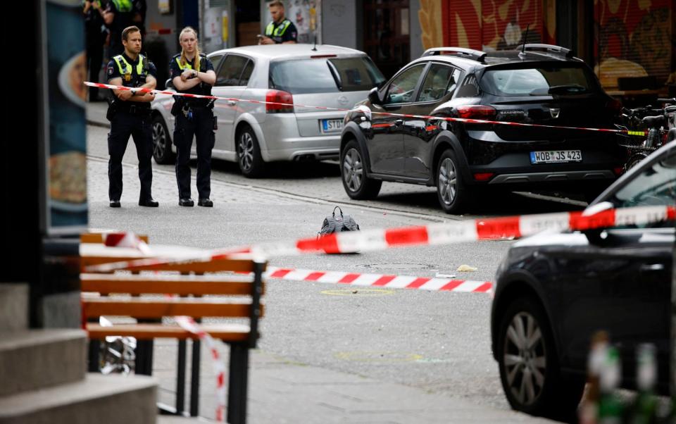 Police officers stand inside a cordon