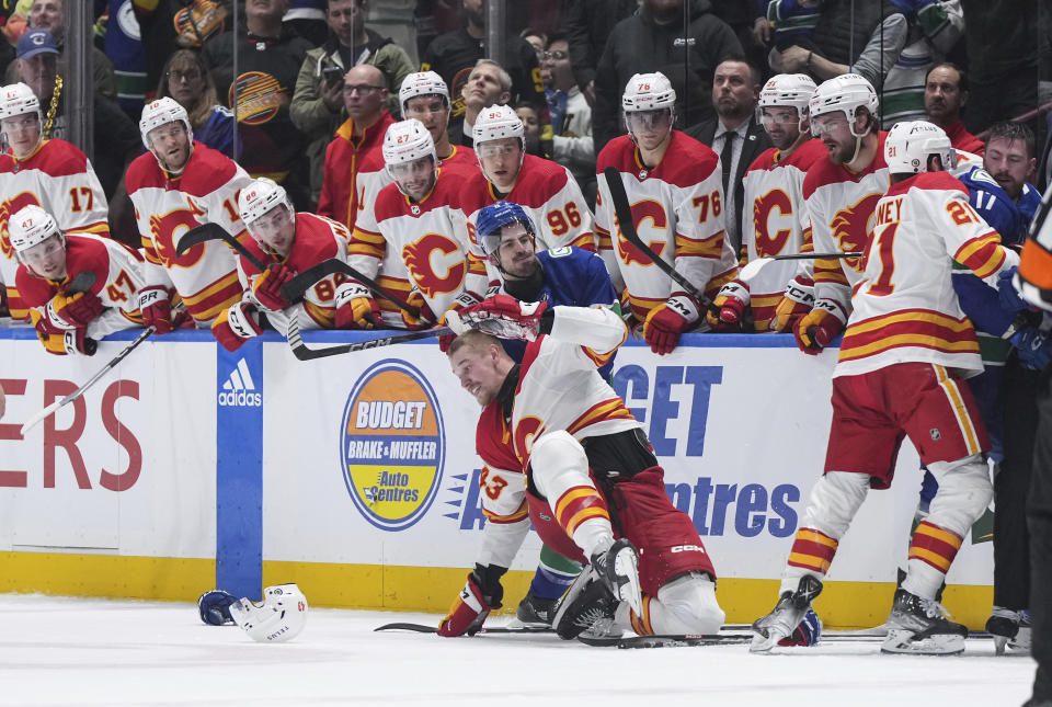 Vancouver Canucks' Conor Garland, back, grabs Calgary Flames' Adam Klapka as all the skaters on the ice get into a scuffle during the second period of an NHL hockey game Tuesday, April 16, 2024, in Vancouver, British Columbia. (Darryl Dyck/The Canadian Press via AP)