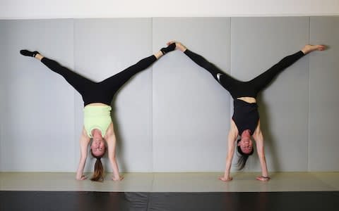 Agnes, left, continues to use the support of walls to help her get into upside-down position - Credit: Clara Molden/The Telegraph