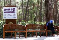 <p>Una mujer se sienta junto a un letrero en el que se muestra la playa o la piscina solo de mujeres.<br>Foto: REUTERS </p>