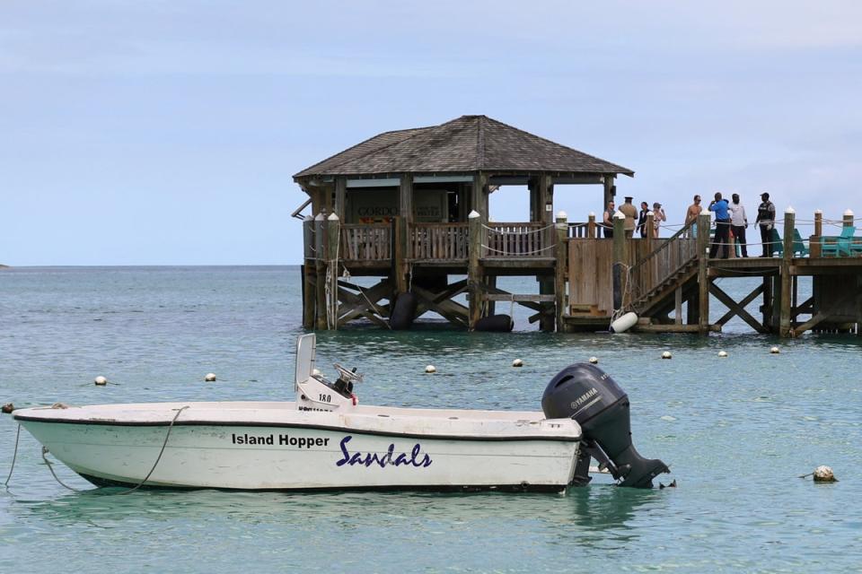 Un grupo de personas se reúne en el muelle del complejo turístico Sandals Royal Bahamian tras el ataque del tiburón. (REUTERS)