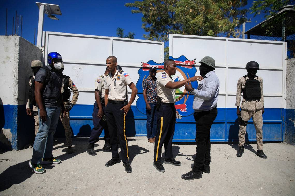 A police officer tries to calm down another police officer dressed in street clothes as he tries to enter the police headquarters during a protest to denounce bad police governance, in Port-au-Prince, Haiti, Thursday, Jan. 26, 2023.