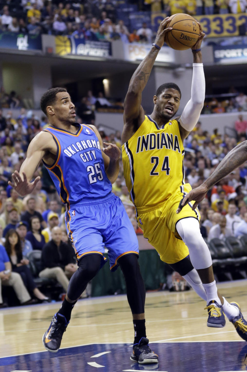 Indiana Pacers forward Paul George (24) cuts in front of Oklahoma City Thunder guard Thabo Sefolosha as he drives the lane in the second half of an NBA basketball game in Indianapolis, Sunday, April 13, 2014. The Pacers defeated the Thunder 102-97. (AP Photo/Michael Conroy)