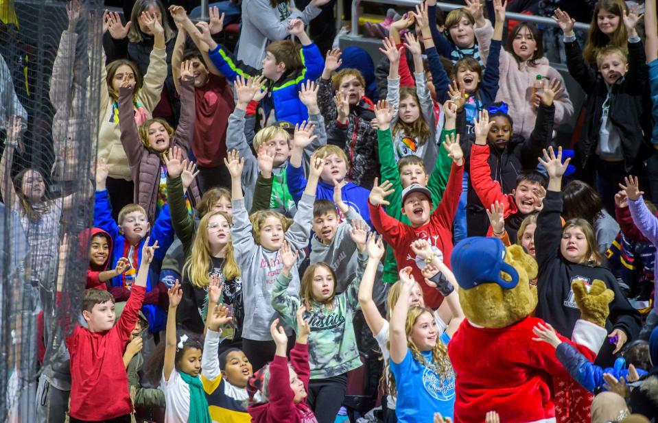 Students try to get the attention of Rivermen mascot Rocky as he tosses T-shirts into the crowd during Education Day activities Thursday, Dec. 15, 2022 at Carver Arena. Thousands of Peoria-area students attended a morning hockey game between the Peoria Rivermen and the Quad City Storm.