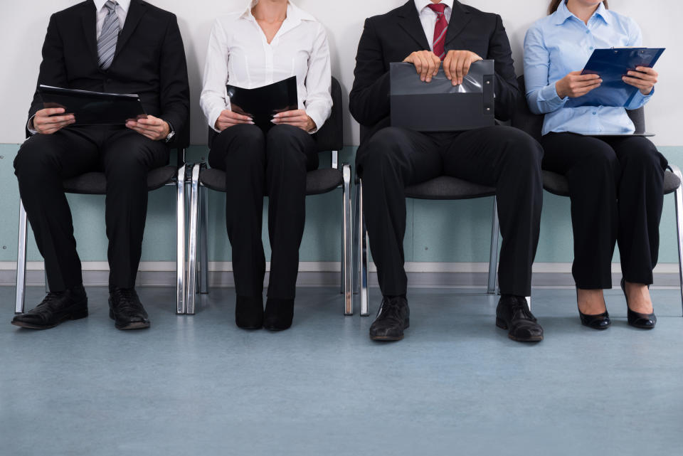 Row of professionally dressed adults sitting in chairs