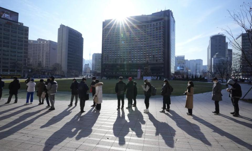 People wait to take coronavirus tests at a makeshift testing site in Seoul