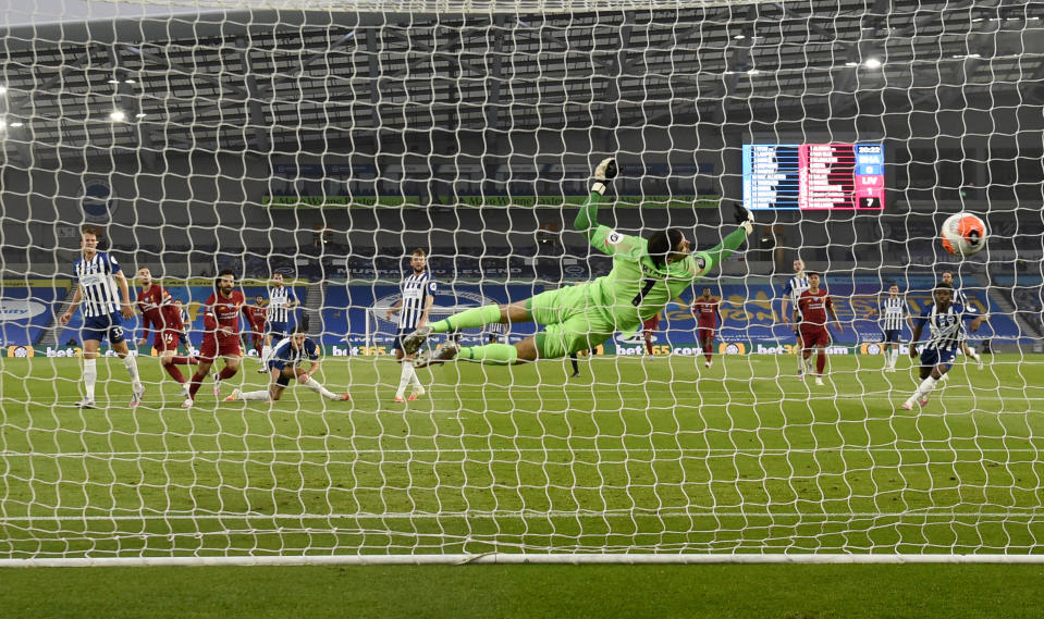 El arquero del Brighton, Matthew Ryan, se lanza infructuosamete en busca de evitar un gol de Jordan Henderson, del Liverpool, en un partido de la Liga Premier, realizado el miércoles 8 de julio de 2020 (AP Foto/Daniel Leal Olivas,Pool)