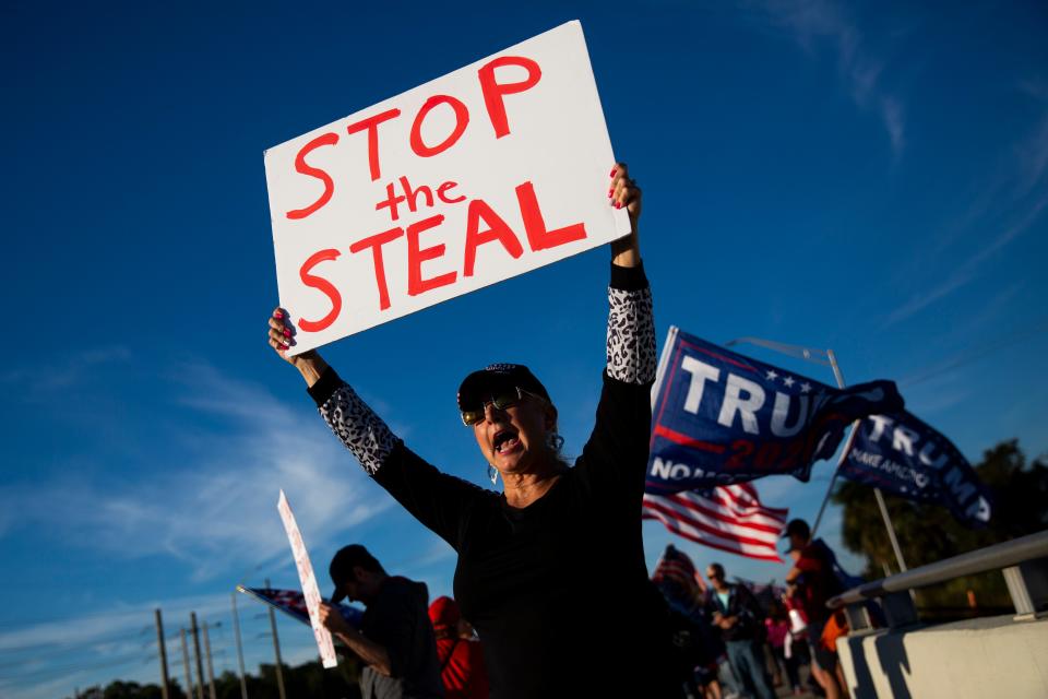 Diane "Feisty" Feist holds up a sign that says "stop the steal" during a pro-Trump protest outside Oakes Farms Seed to Table in North Naples, Florida, on Jan. 6, 2021.