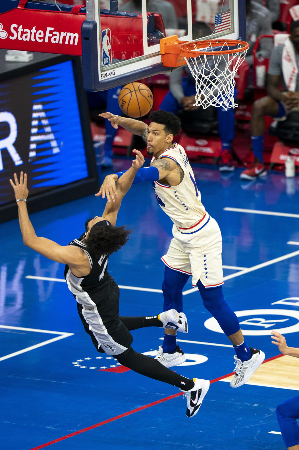 Philadelphia 76ers' Danny Green, right, defends against a shot by San Antonio Spurs' Derrick White, left, during the first half of an NBA basketball game, Sunday, March 14, 2021, in Philadelphia. (AP Photo/Chris Szagola)