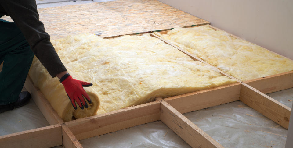 Work composed of mineral wool insulation in the floor, floor heating insulation , warm house, eco-friendly insulation, a builder at work