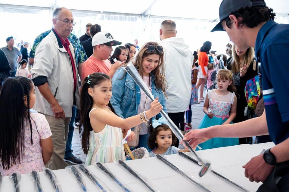 Jacky Ortega, 9, receives a putter that she won as a prize on Sunday, April 9, 2023, during the Haggin Oaks Easter Egg Hunt as her mother Susana Herrera, center, and sister Jaclyn, 2, watch after the Sacramento event.