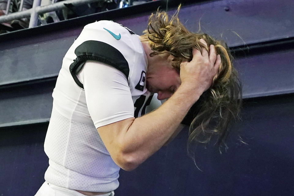Jacksonville Jaguars quarterback Trevor Lawrence scratches his head while heading to the locker room after a 50-10 loss to the New England Patriots after an NFL football game, Sunday, Jan. 2, 2022, in Foxborough, Mass. (AP Photo/Steven Senne)