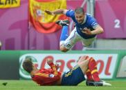 TOPSHOTS Italian midfielder Thiago Motta (top) falls over Spanish defender Gerard Pique during the Euro 2012 championships football match Spain vs Italy on June 10, 2012 at the Gdansk Arena. AFP PHOTO / GABRIEL BOUYSGABRIEL BOUYS/AFP/GettyImages