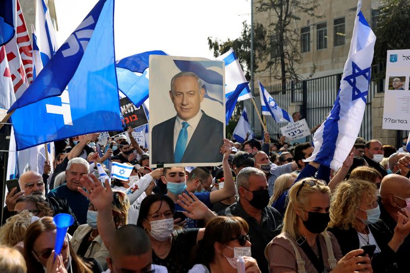 Supporters of Israeli Prime Minister Benjamin Netanyahu, wave flags and hold a placard depicting Netanyahu, during a rally as Netanyahu's corruption trial resumes, near Jerusalem's District Court