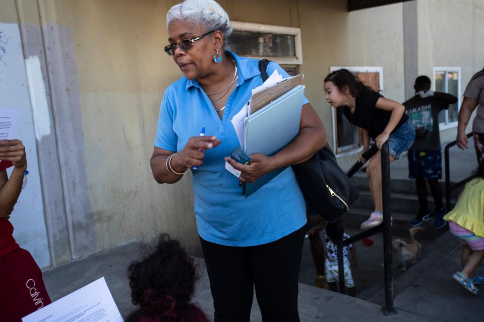 Sonya Gray-Hunn, the lead housing organizer at Congregations Organized for Prophetic Engagement, passes out information to tenants of an unpermitted housing complex in San Bernardino, Calif., on October 5, 2022. 