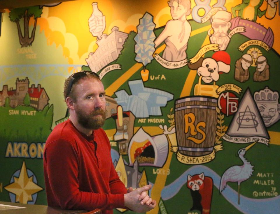 Ron Shea, co-founder of R. Shea Brewing poses in front of a mural that features Akron area brewers historic and contemporary at their Canal Place location in Akron. The brewery's Merriman Valley and their downtown Akron brewery will close on March 3.