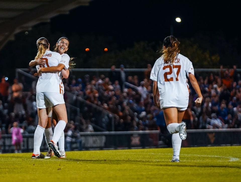 Texas women's soccer players Lexi Missimo and Holly Ward embrace while Ashlyn Miller (27) runs towards them after Ward's goal during Big 12 Championship final Saturday, Nov. 4, 2023 at Round Rock Multipurpose Complex.