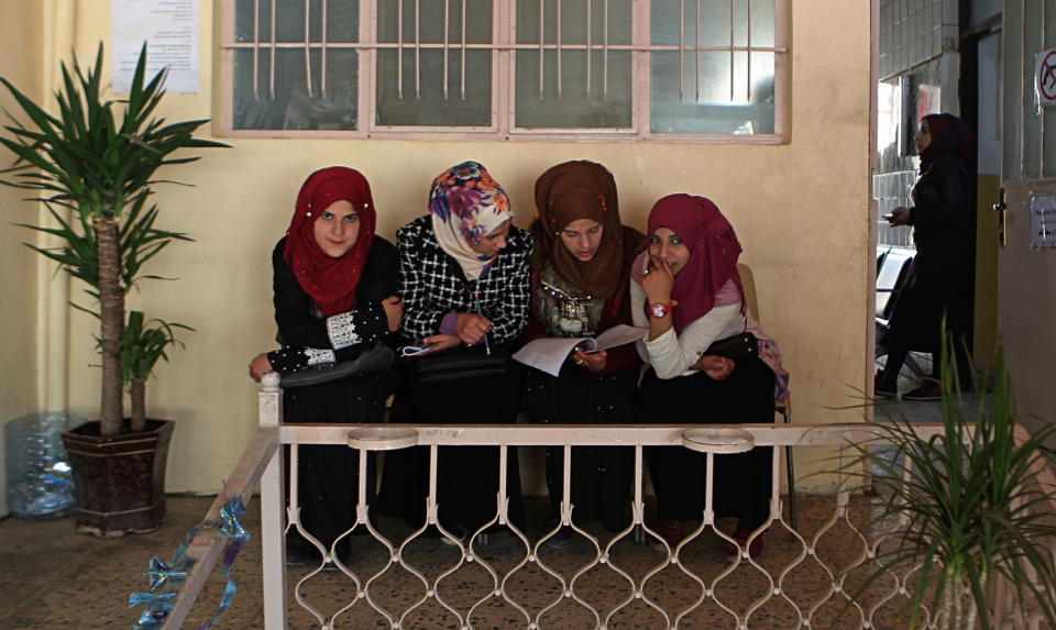 In this Feb. 26, 2019 photo, women wait for legal advice in a legal clinic supported by the Norwegian Refugee Council, in west Mosul, Iraq. Thousands of Iraqi families face crushing social and legal discrimination -- all because of the choices their male relatives made under the Islamic State group’s rule. They’ve been disowned by relatives and abandoned by the state. (AP Photo/Khalid Mohammed)