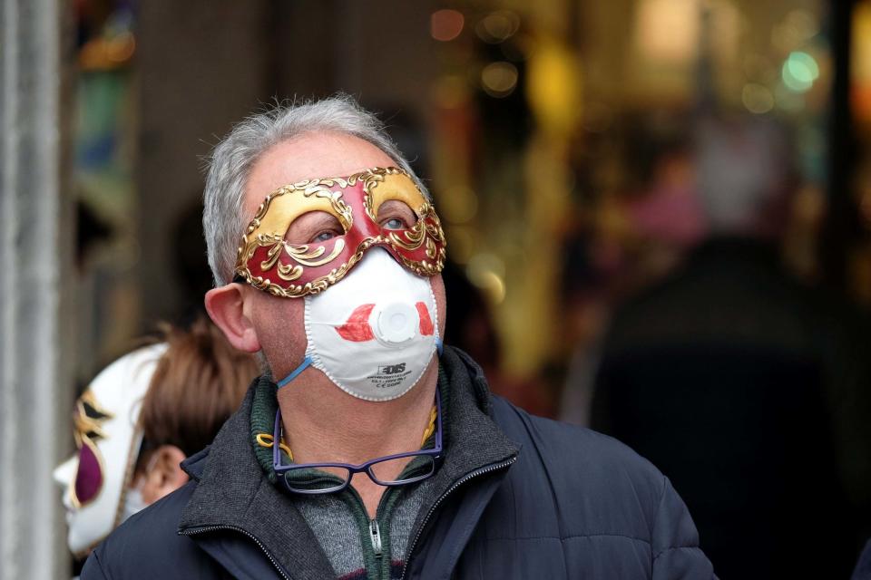 A masked carnival reveller wears protective face mask at Venice Carnival (REUTERS)