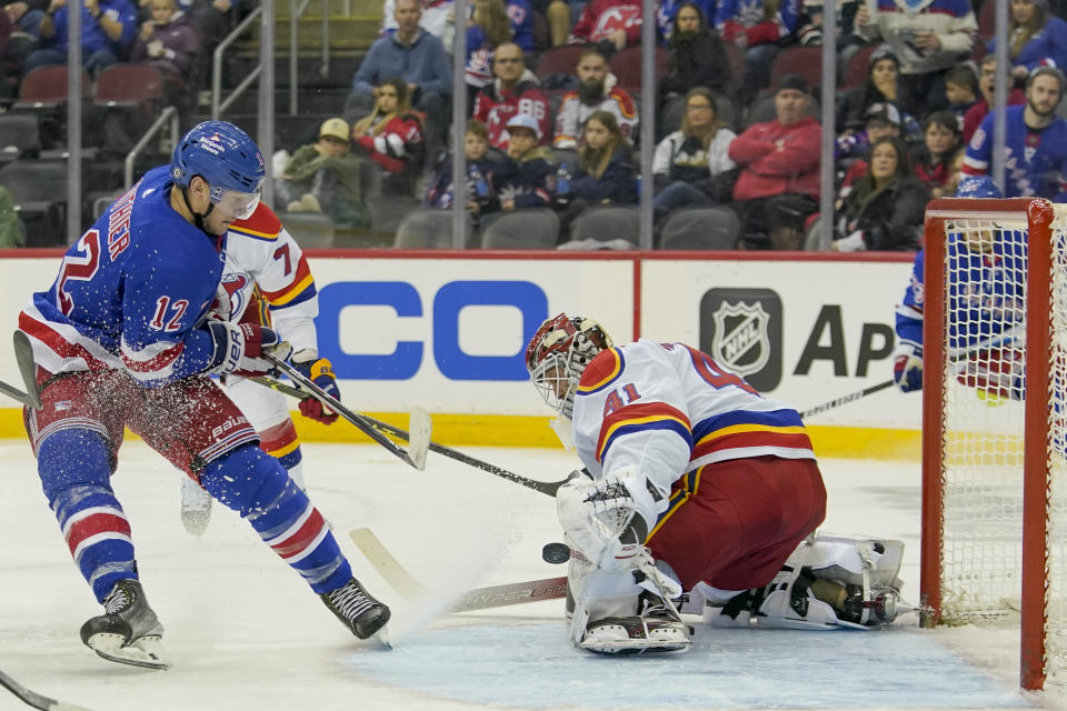 New York Rangers right wing Julien Gauthier (12) scores past New Jersey Devils goaltender Vitek Vanecek (41) during the second period of an NHL hockey game, Saturday, Jan. 7, 2023, in Newark, N.J. (AP Photo/Mary Altaffer)