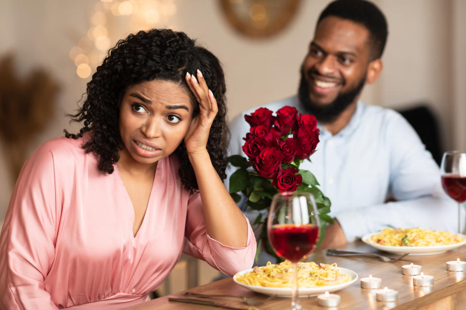 Woman cringing on date with a man