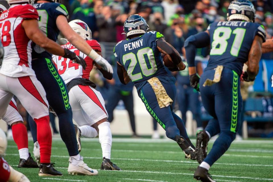 Seattle Seahawks running back Rashaad Penny (20) carries the ball as Arizona Cardinals free safety Jalen Thompson (34) looks to track him down during the first quarter of an NFL game on Sunday afternoon at Lumen Field in Seattle.