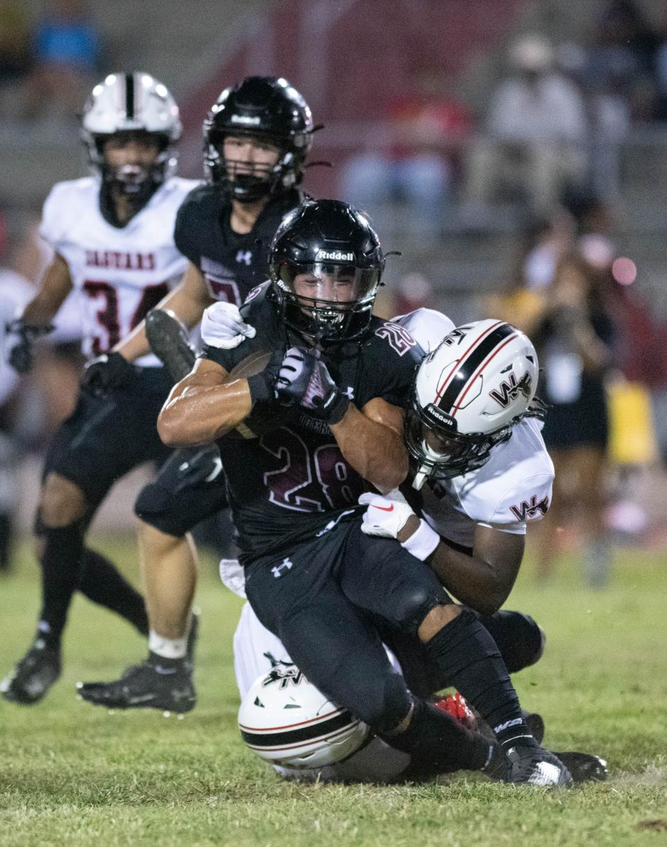 Connor Mathews (28) is tackled by Jordyn Moorer (7) during the West Florida vs Navarre preseason football game at Navarre High School on Friday, Aug. 18, 2023.