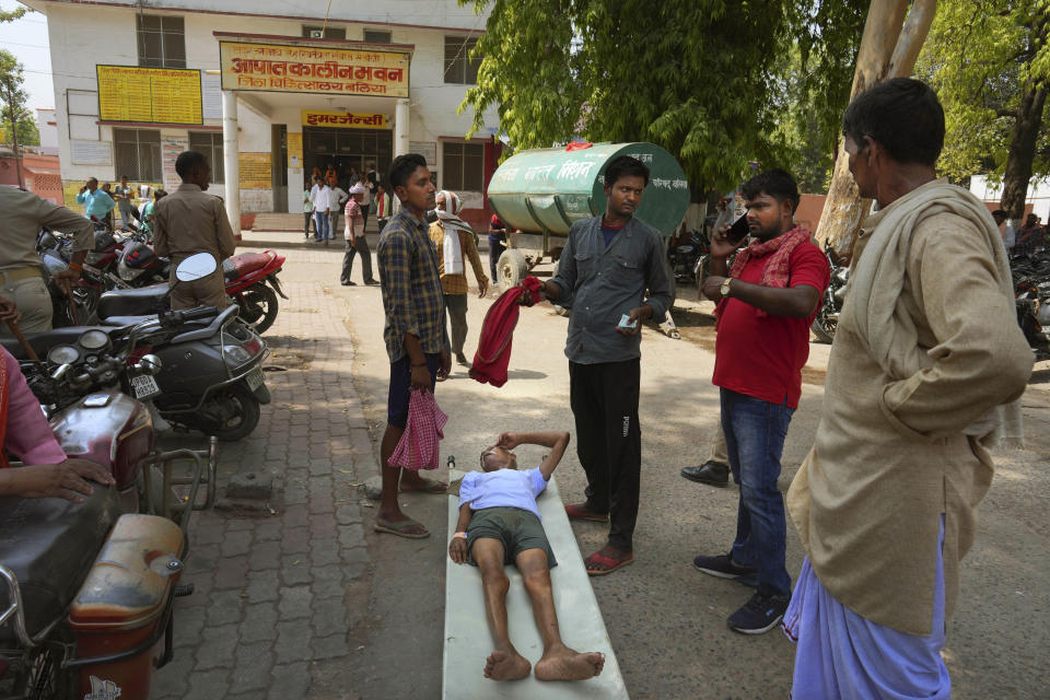 An elderly person suffering from heat related ailment lies on a stretcher waiting to get admitted outside the overcrowded government district hospital in Ballia, Uttar Pradesh state, India, Monday, June 19, 2023. Several people have died in two of India's most populous states in recent days amid a searing heat wave, as hospitals find themselves overwhelmed with patients. More than hundred people in the Uttar Pradesh and dozens in neighboring Bihar have died due to heat-related illness. (AP Photo/Rajesh Kumar Singh)