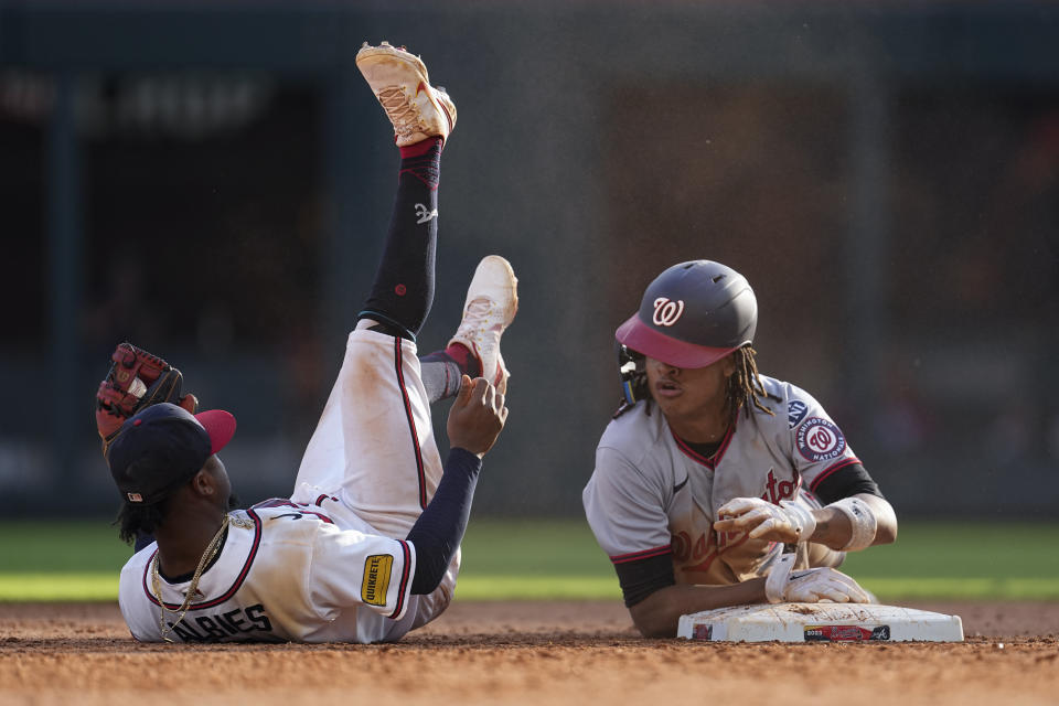 Washington Nationals CJ Abrams (5) is safe second base with a stolen base as Atlanta Braves second baseman Ozzie Albies (1) rolls off the base in the eighth inning of a baseball game, Sunday, Oct. 1, 2023, in Atlanta. (AP Photo/John Bazemore)